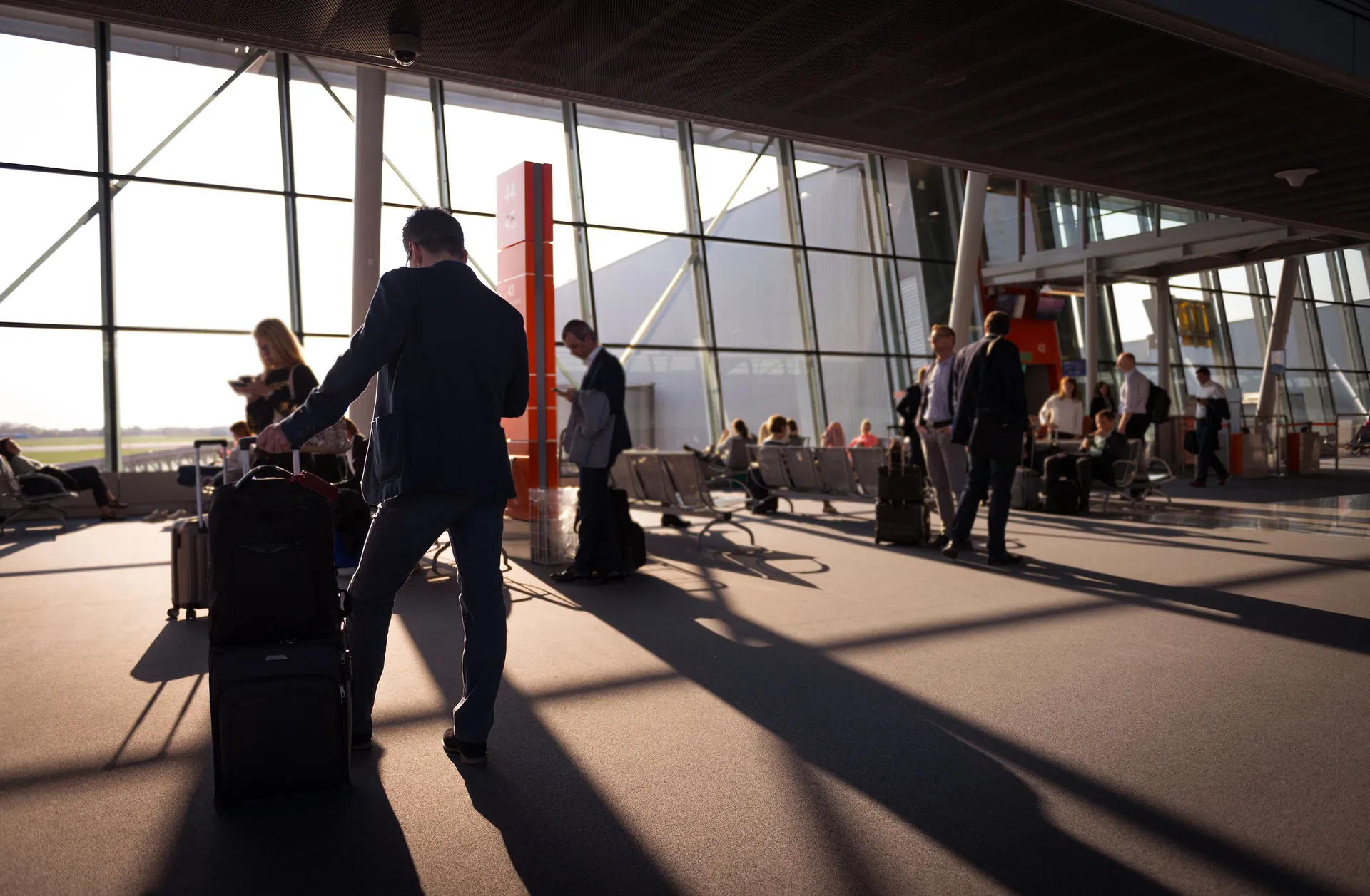 A business traveller with luggage in a sunlit terminal